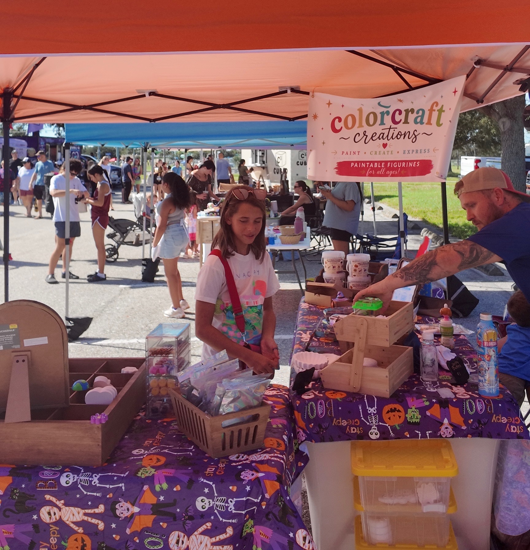 A young Biz Kidz maker at the Colorcraft Creations stand selling paintable figurines