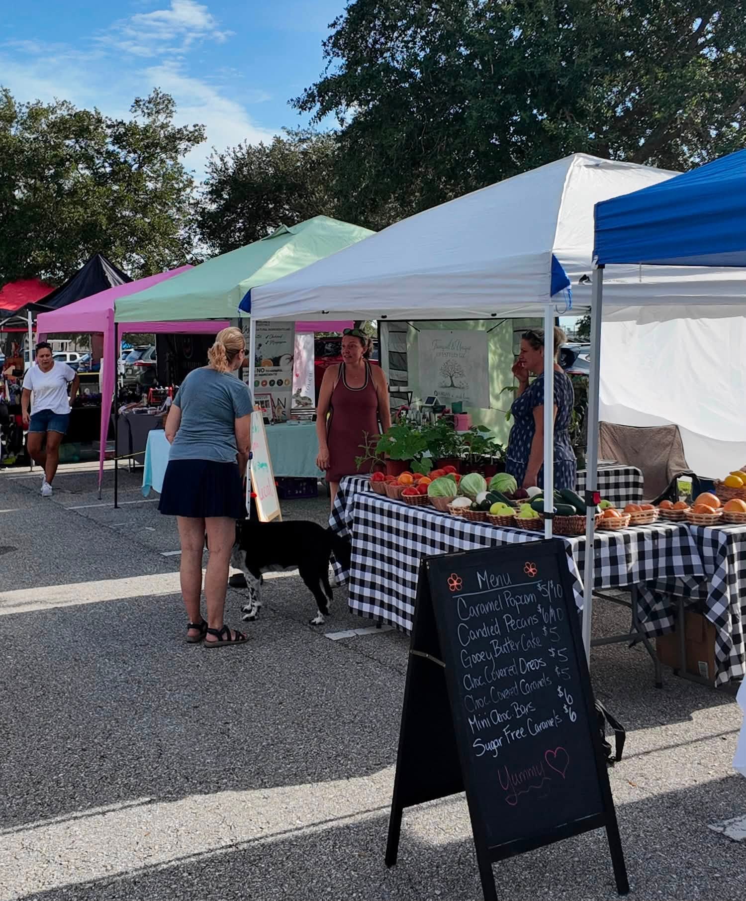 Colorful pop-up tents lined up with tables of fresh fruit and vegetables